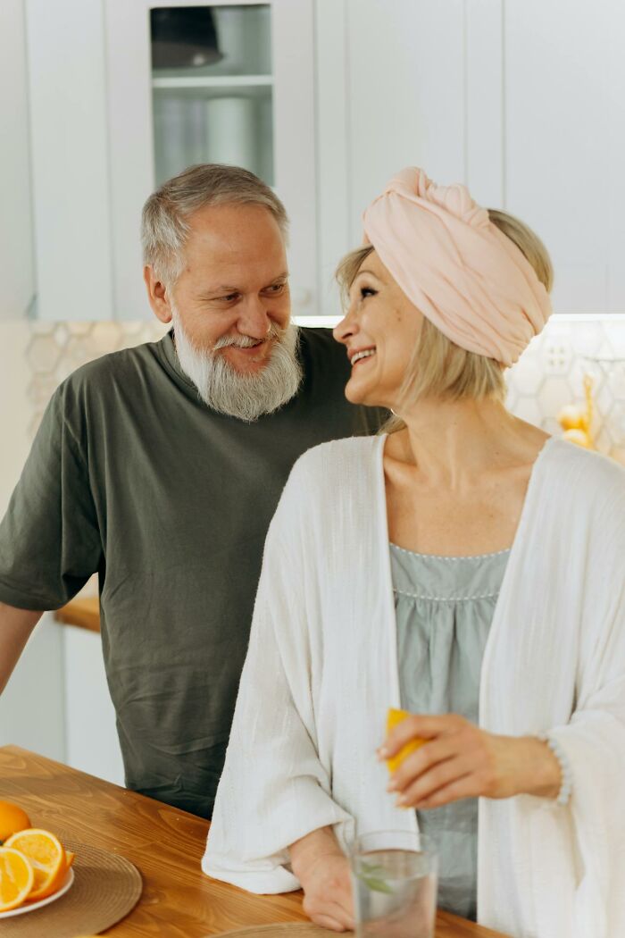 Mature couple sharing a moment in the kitchen, reflecting on harsh truths about marriage after experience.