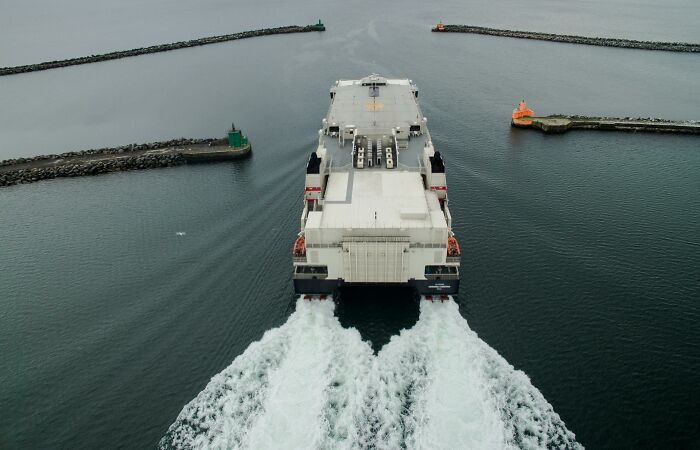 Ferry boat leaving harbor with wave trails, illustrating absurd but true stories that are hard to believe.