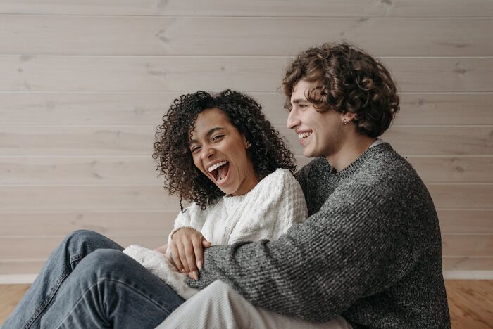 Couple sitting together laughing and enjoying a moment, illustrating harsh truths about marriage reality and relationships.