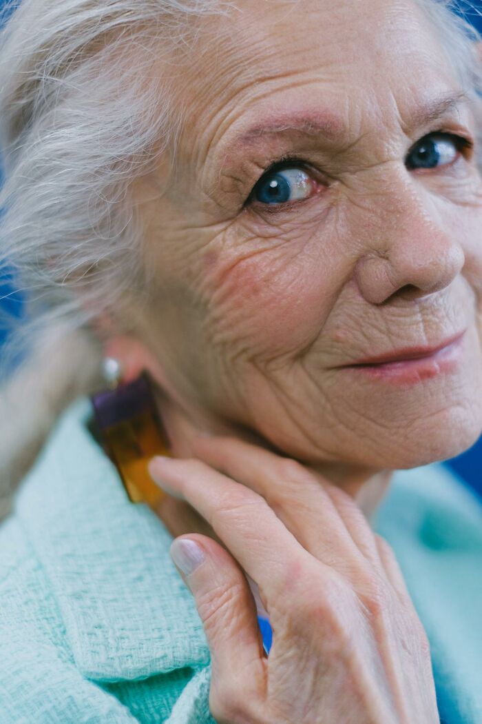 Close-up of an elderly woman with blue eyes and wrinkles, symbolizing psych ward nurses’ intense experiences.