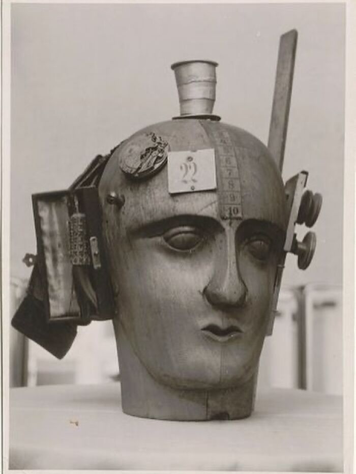 Wooden mannequin head with attached antique objects, a very old artifact showing history of ancestors and craftsmanship.