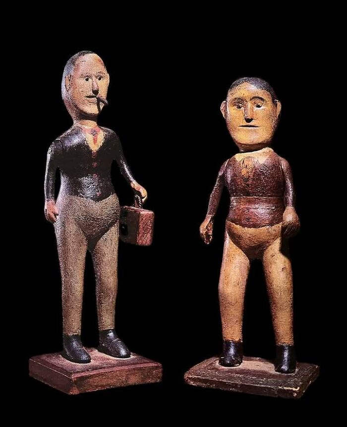 Two very old wooden figures standing on square bases, showcasing ancient objects from our ancestors' time.