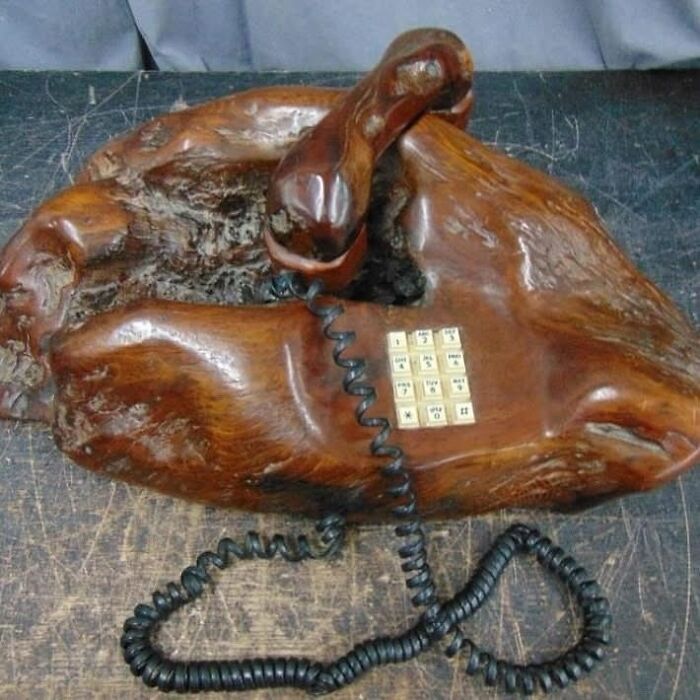 Vintage wooden telephone with rotary dial and coiled cord, an old object that tells stories about our ancestors.