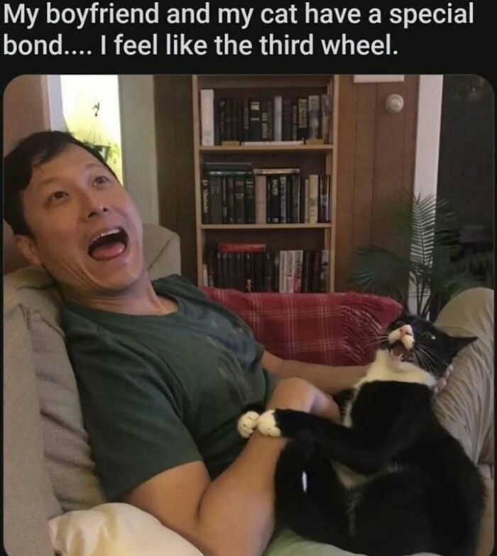Man making a surprised face while holding a black and white cat, showcasing a funny cat memes moment.
