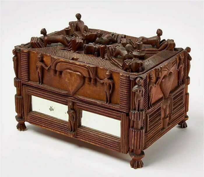 Intricately carved very old wooden box with ancestral figures and heart motifs, showcasing ancient craftsmanship and history.