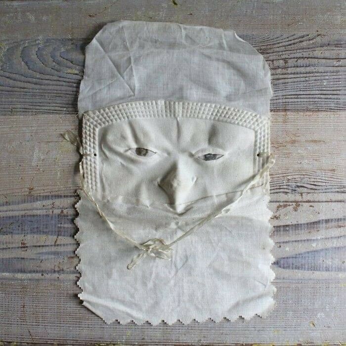 Very old cloth mask with carved facial features, an ancient object that survived to tell stories about our ancestors.