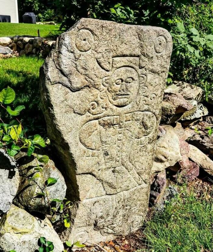 Ancient carved stone with detailed human figure and symbols, one of the very old objects showing stories about ancestors.
