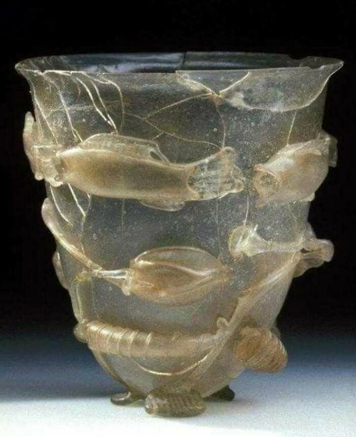 Ancient glass cup with intricate fish and aquatic designs, a very old object surviving to tell stories about ancestors.