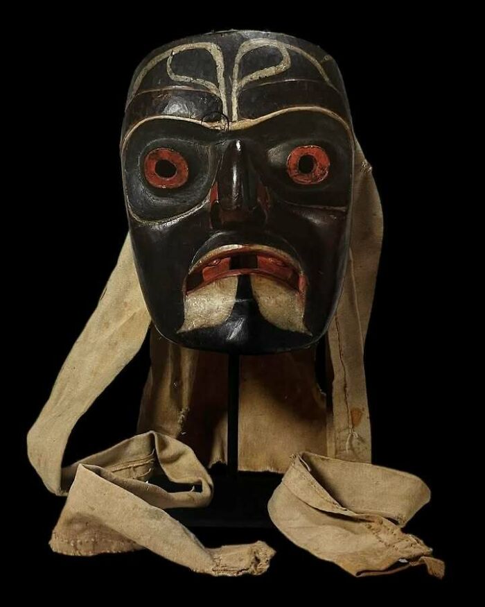 Carved wooden ancestral mask with fabric ties, an old object that survived to tell stories about our ancestors.