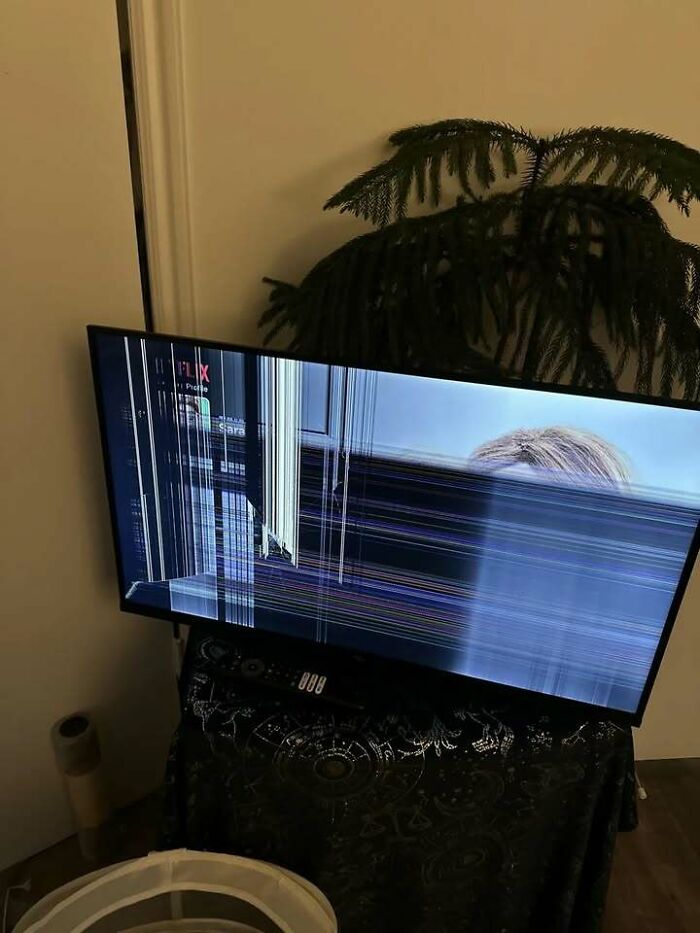 Broken TV screen showing distorted image in a living room, illustrating messy times people turn to the internet over therapy.