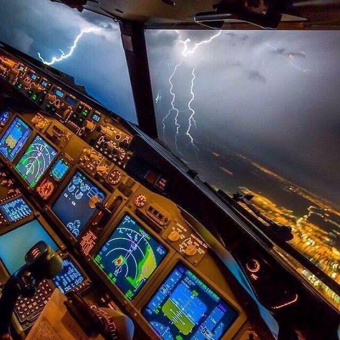 Cockpit view of a plane facing lightning storm, showing pilots handling terrifying situations with calmness inside.