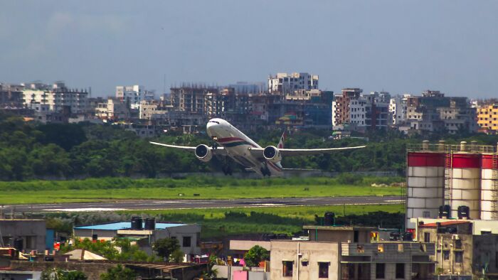 Commercial airplane taking off near urban buildings, illustrating pilots handling terrifying situations with calmness.