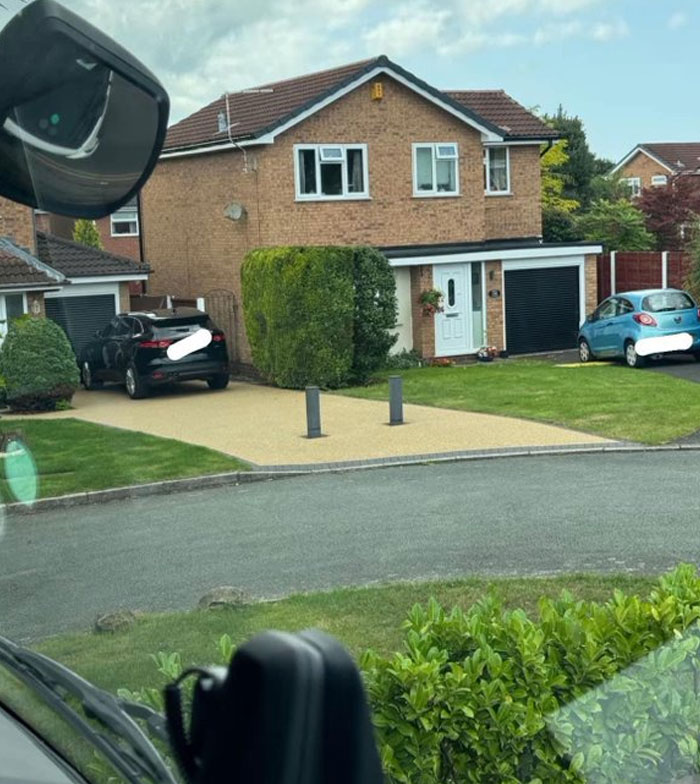 House with two bollards blocking driveway entrance, showcasing design and architecture nightmares with poor common sense planning.