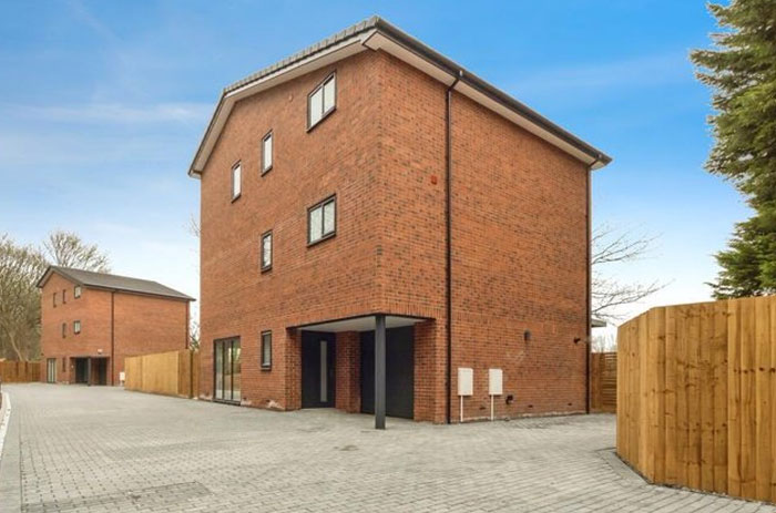 Modern brick building with unusual overhanging section supported by single pillar, illustrating design and architecture nightmares.