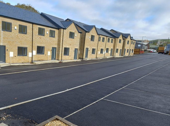 Row of identical modern houses with no visible sidewalk or parking access, illustrating design and architecture nightmares.