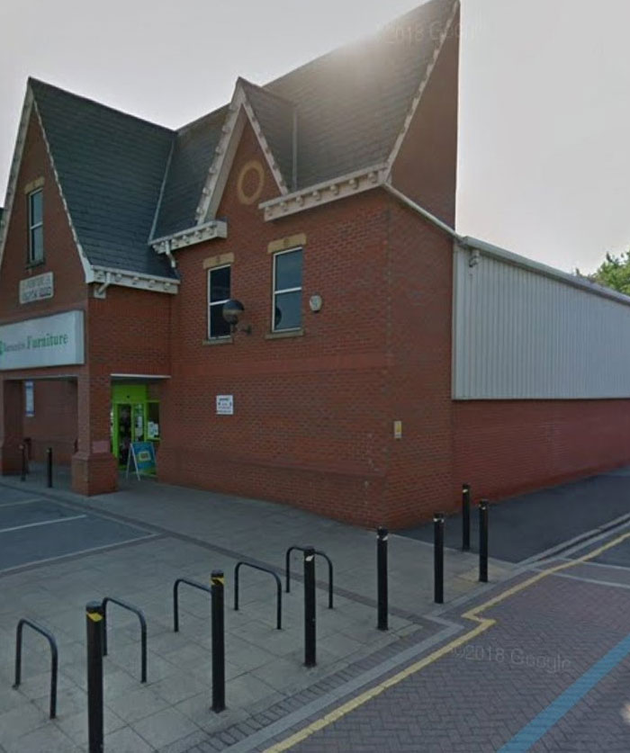 Brick building with odd architecture and poorly placed barriers, a clear example of design and architecture nightmares.