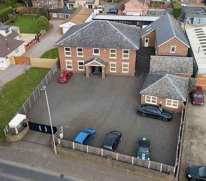 A building with a large empty parking lot blocking the entrance, illustrating a design and architecture nightmare.