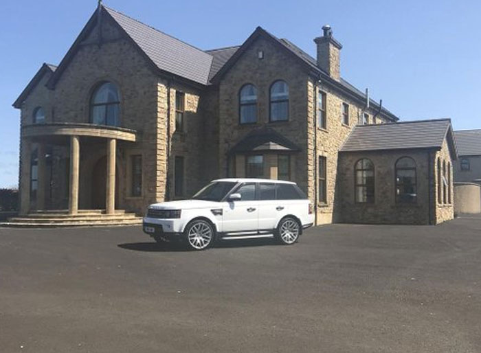 Stone house with mismatched arched windows and entrance columns, illustrating design and architecture nightmares.