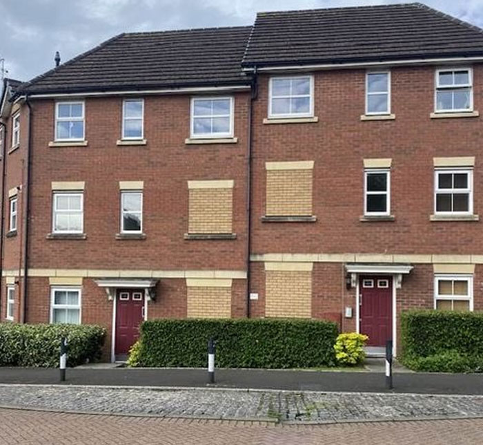 Brick townhouses with multiple windows and some windows and doors covered by bricks highlighting design and architecture nightmares.