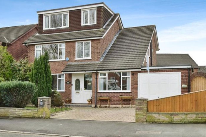 Brick house with sloped roof and garage, showcasing a design and architecture nightmare with common sense flaws.