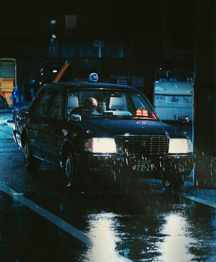 Two men inside a taxi at night in the rain, illustrating dumb drivers instantly getting what they deserved.