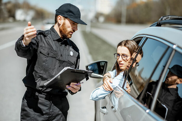 Police officer talking to a driver during a traffic stop, illustrating dumb drivers instantly getting consequences.