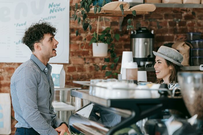 Couple sharing a happy moment in a cozy cafe, illustrating relationship gestures and positive interactions.