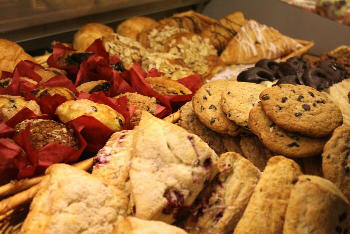Assorted baked goods including cookies, croissants, and muffins arranged on a tray representing relationship gestures.