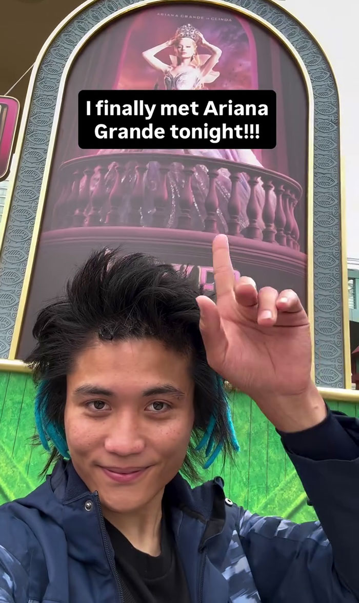 Young man pointing at a theater poster selfie, unrelated to Michelle Yeoh&rsquo;s outfit or wasp nest premiere meltdown online.