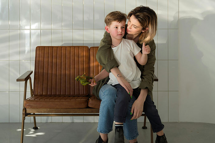 Mother and child sitting on a bench, showing emotional connection reflecting parents and children reasons for unhappiness.