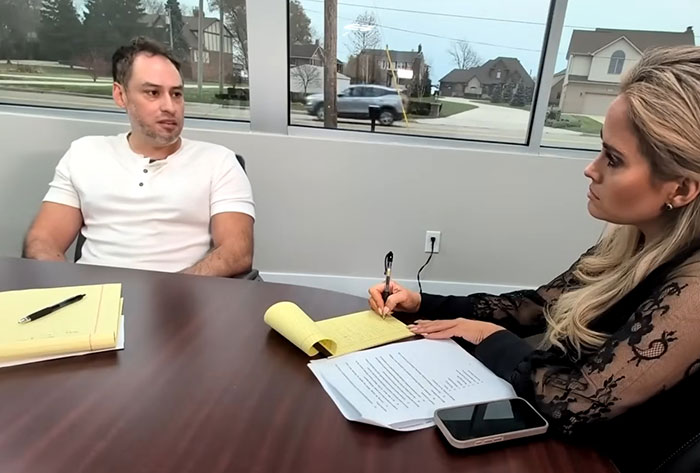 Man in white shirt and woman taking notes during an interview about Campbell's executive disturbing comments on soup ingredients.