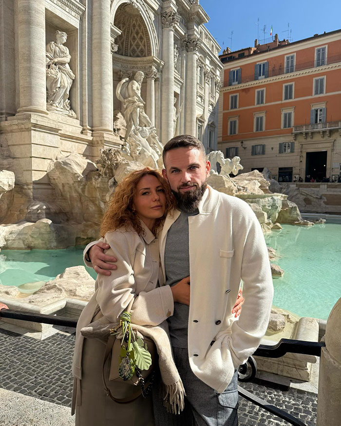 Couple posing by a historic fountain in a European city, unrelated to crypto scammer behind $500M scheme news.