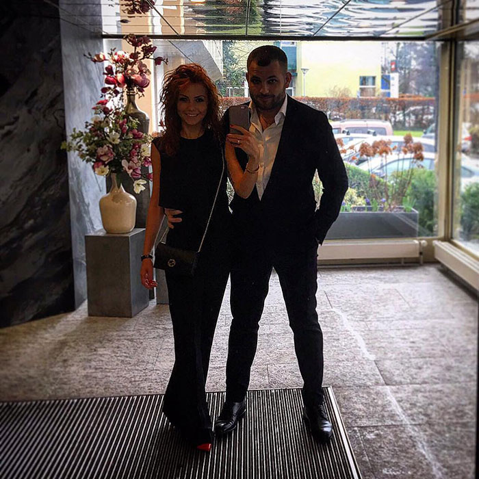 Couple posing indoors, dressed formally, representing the crypto scammer behind $500M scheme and his wife in Dubai.