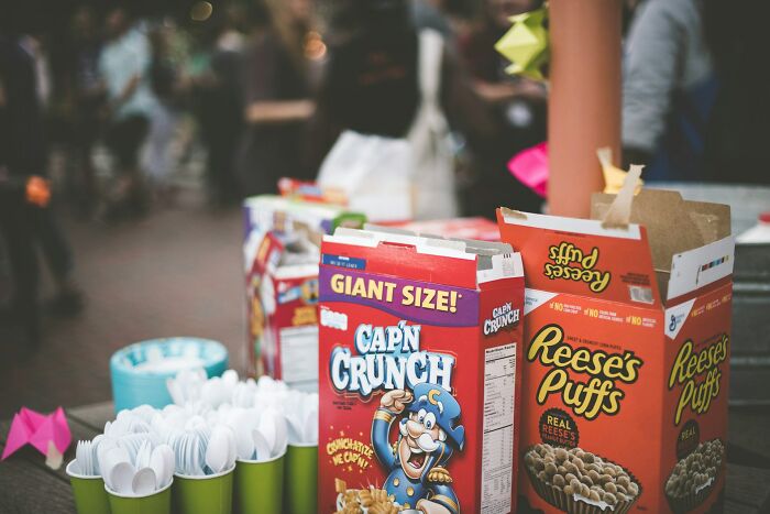 Colorful cereal boxes of Cap'n Crunch and Reese's Puffs displayed on a table, highlighting surprising habits after moving in together.