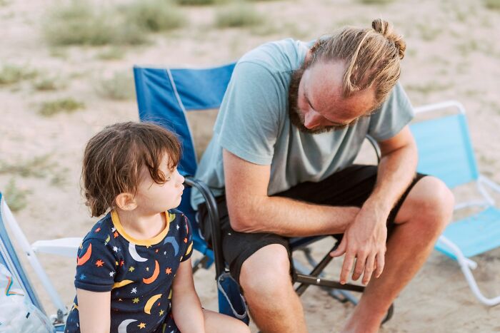 Father and child sitting outdoors having a serious conversation, illustrating common ways parents fail at raising kids.