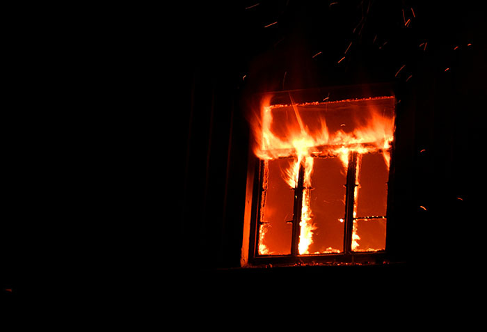 Window engulfed in flames at night, illustrating one of the scariest things people have woken up to incidents.
