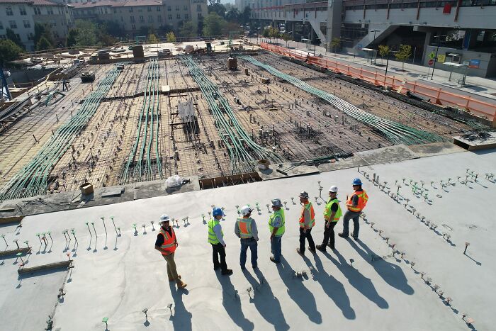 Construction workers at a large site inspecting groundwork and piping, illustrating times folks wanted to say something funny but hurt loved ones.