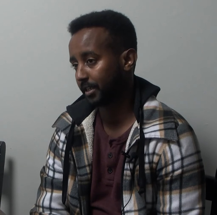 Man in plaid jacket speaking during interview about viral mom who called autistic boy the N-word in playground clash trial