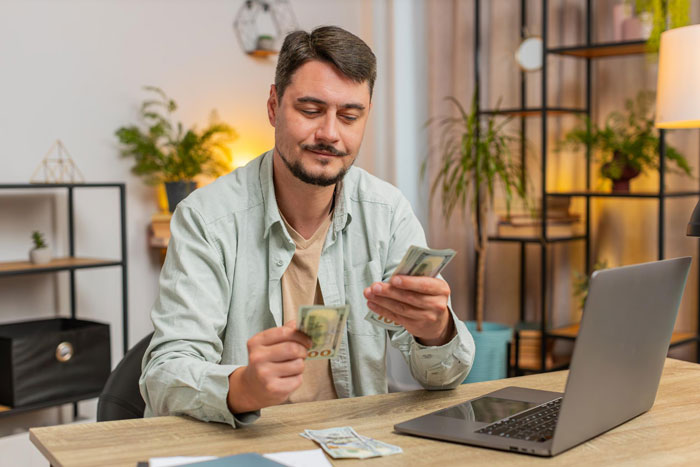 Man counting money at home, illustrating the concept of asking husband for money when sick and in need of support.