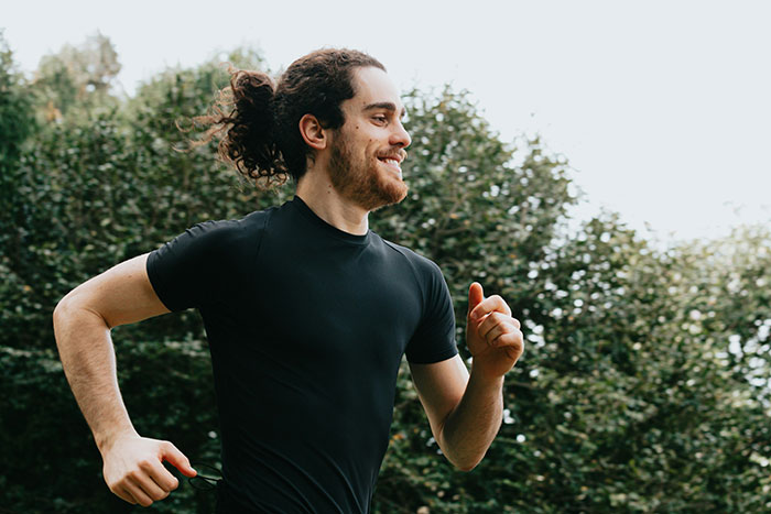 Man with a ponytail running outdoors in a black shirt, representing lies that had a bigger effect on people’s lives than expected.