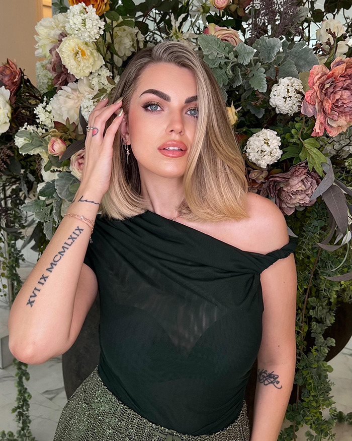 Young influencer with shoulder-length blonde hair posing in front of floral backdrop amid mystery and chilling messages surrounding vanishing.