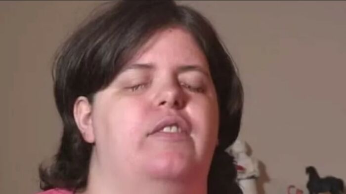 Woman with closed eyes speaking indoors, illustrating unusual and strange facts about our world in a casual setting.