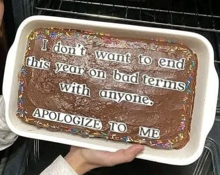 Chocolate cake with humorous message made from cut-out paper letters, fitting the theme of stupid food memes for stupid people.