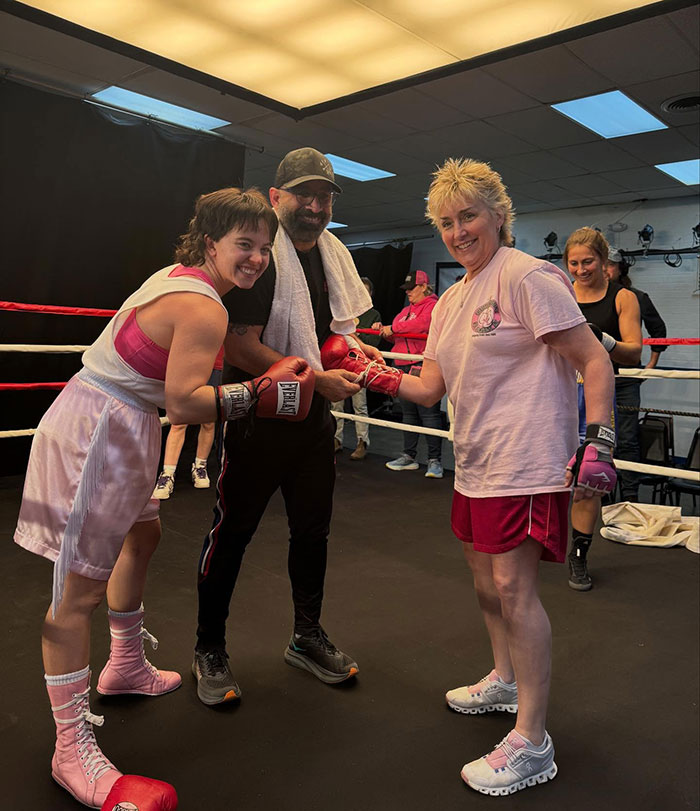 Plus-size model in boxing gear with trainers in a ring, highlighting fitness and body confidence themes. Plus-size model in boxing gear with trainers in a ring, highlighting fitness and body confidence themes.