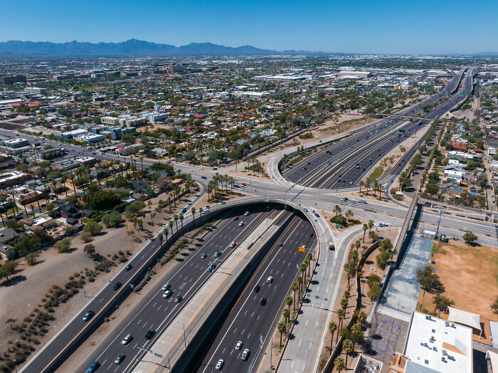 Aerial view of a busy highway and city landscape illustrating quintessentially American infrastructure and culture.