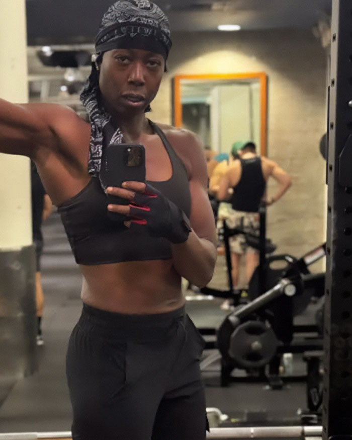 Woman taking a gym mirror selfie, wearing workout clothes and headscarf, related to lesbian removed from gym controversy.