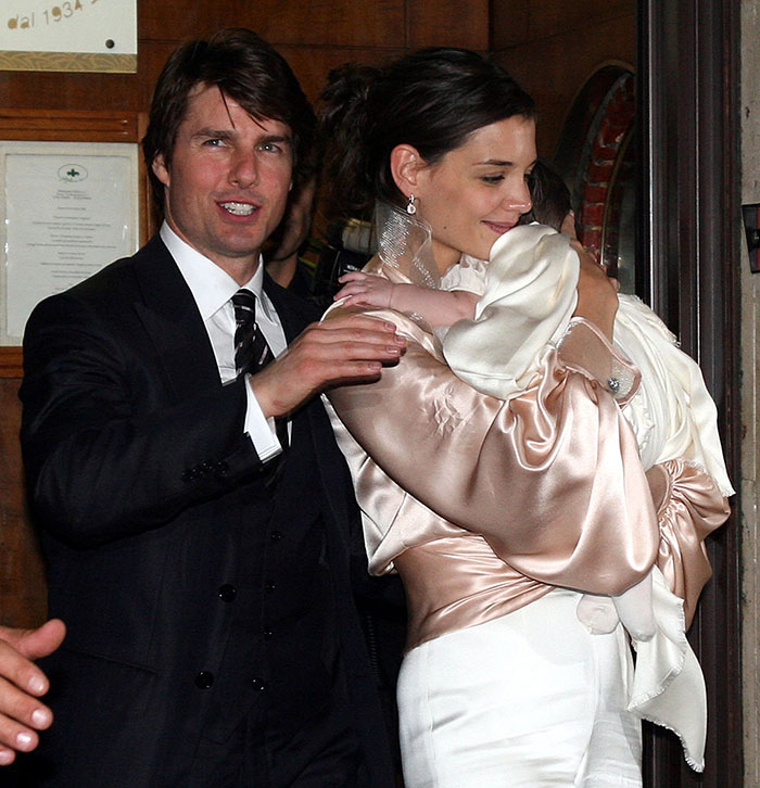 Tom Cruise smiling in suit next to Nicole Kidman holding a baby, related to Karma and Nicole Kidman split news.