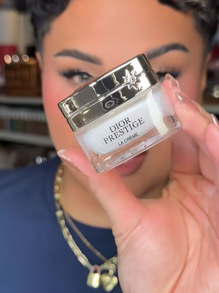 Person holding a jar of Dior Prestige cream, related to Dior advent calendar and luxury beauty product discussion.