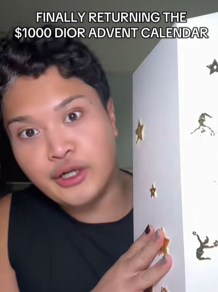 Person holding a large white box decorated with gold stars, referencing the $1000 Dior advent calendar return.