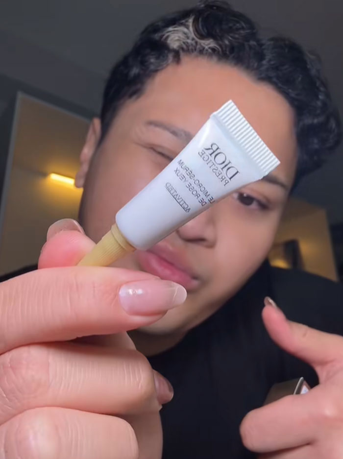 Person holding a small Dior skincare product, highlighting the luxury brand behind the expensive advent calendar.